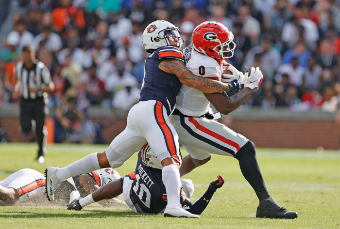 Oct 9, 2021; Auburn, Alabama, USA; Georgia Bulldogs tight end Darnell Washington (0) is tackled by Auburn Tigers safety Zion Puckett (10) and Auburn Tigers safety Donovan Kaufman (1) during the second quarter at Jordan-Hare Stadium. Mandatory Credit: John Reed-USA TODAY Sports